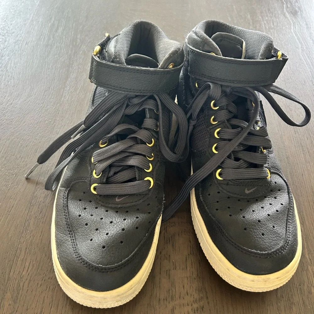 Nike Air Force ones black high top sneakers gold trim